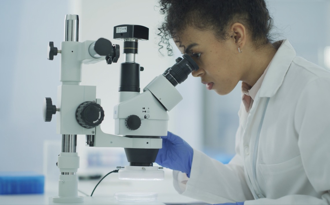 Female Scientist Looking into Microscope _Micro Nano Technology