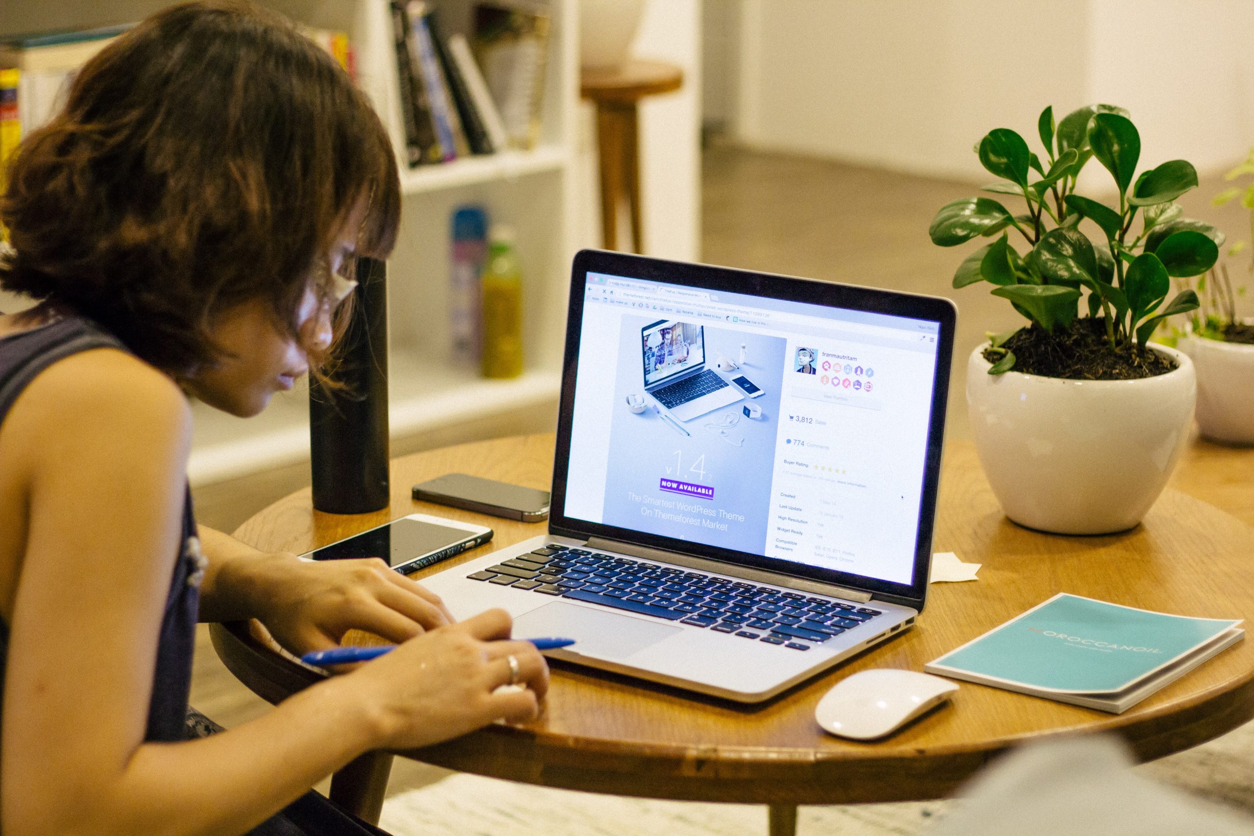 Photo of female sitting at desk with laptop and notebook.